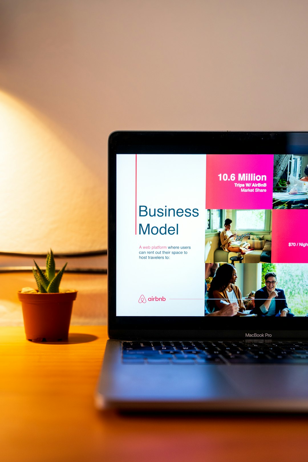 A laptop showing a startup pitch deck with the business model slide shown on the screen.