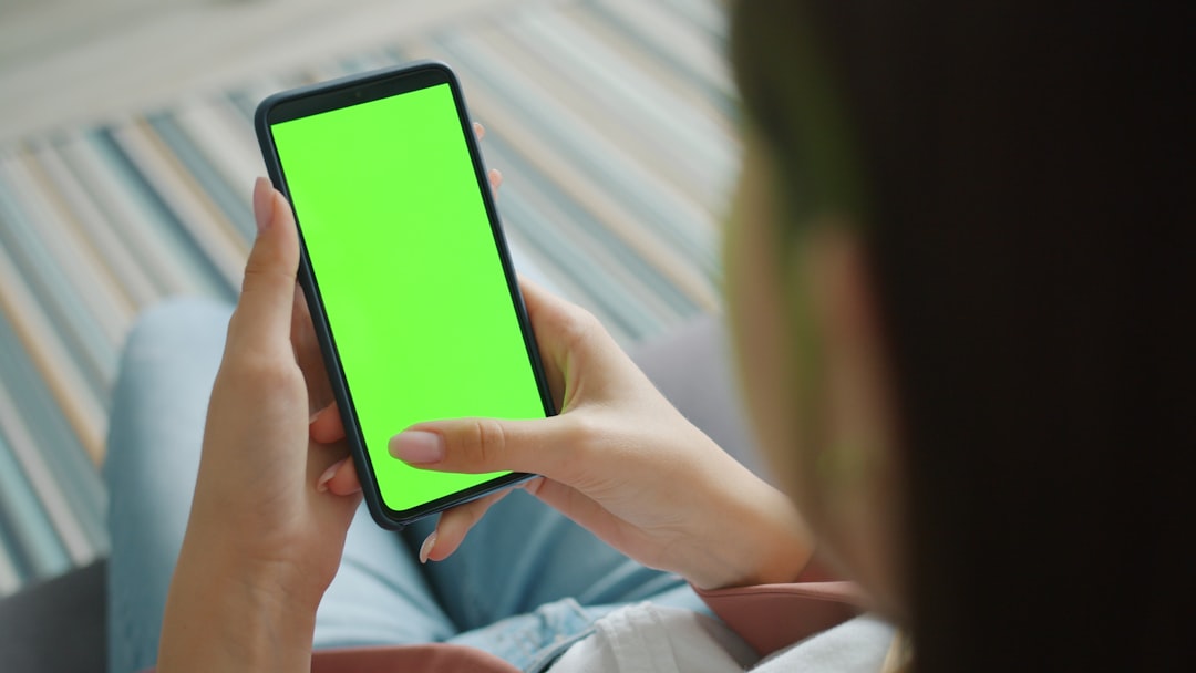 girls hand holding smartphone with chroma key green screen swiping touching modern device enjoying content. People and gadgets concept.